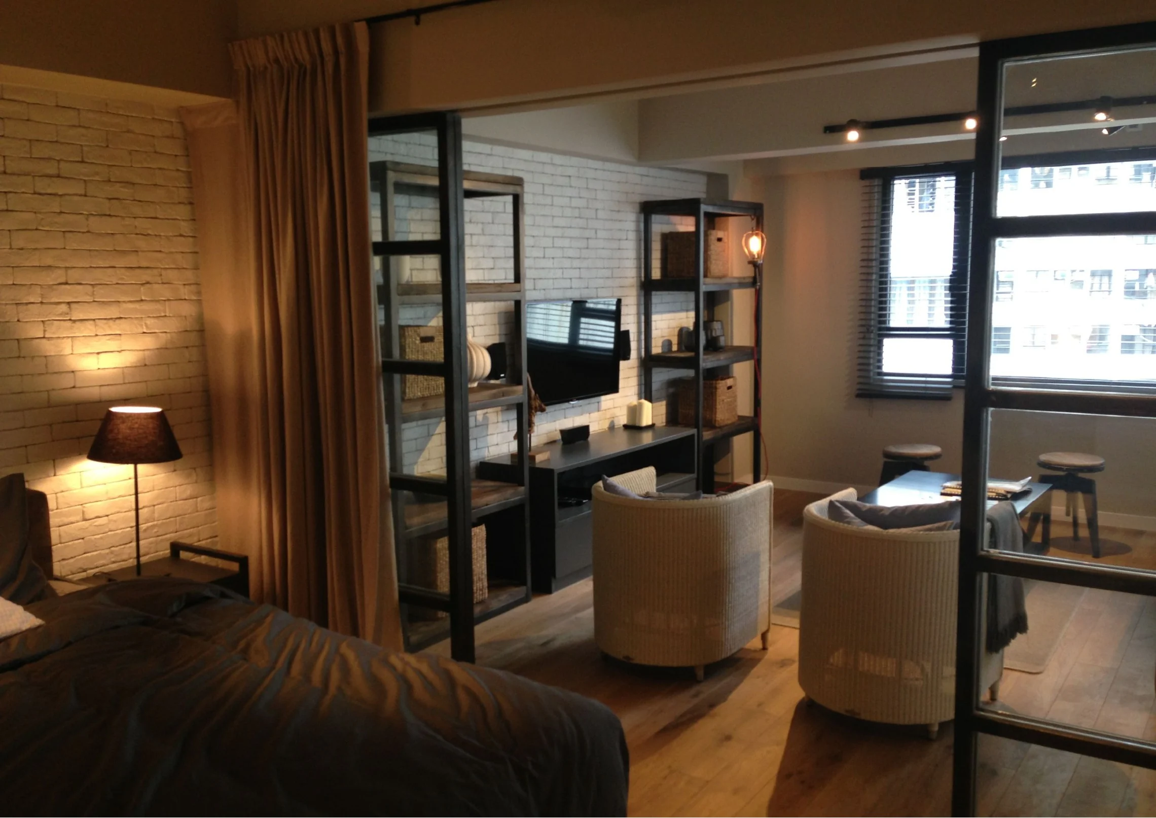 Bedroom and adjacent living area with open display shelving in the Central home