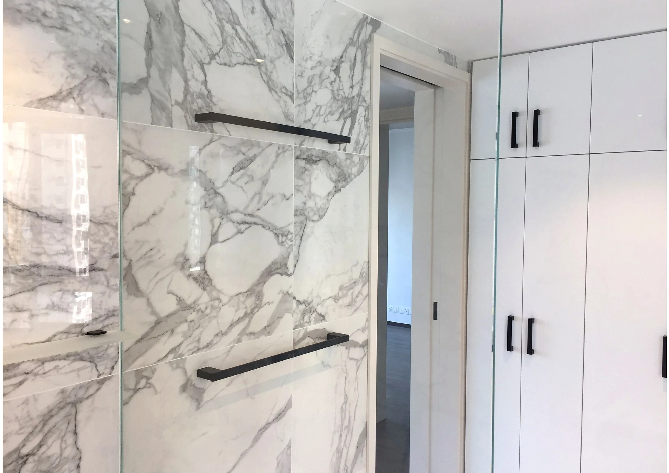 Marble wall finishes and crisp white joinery in a Central residential interior