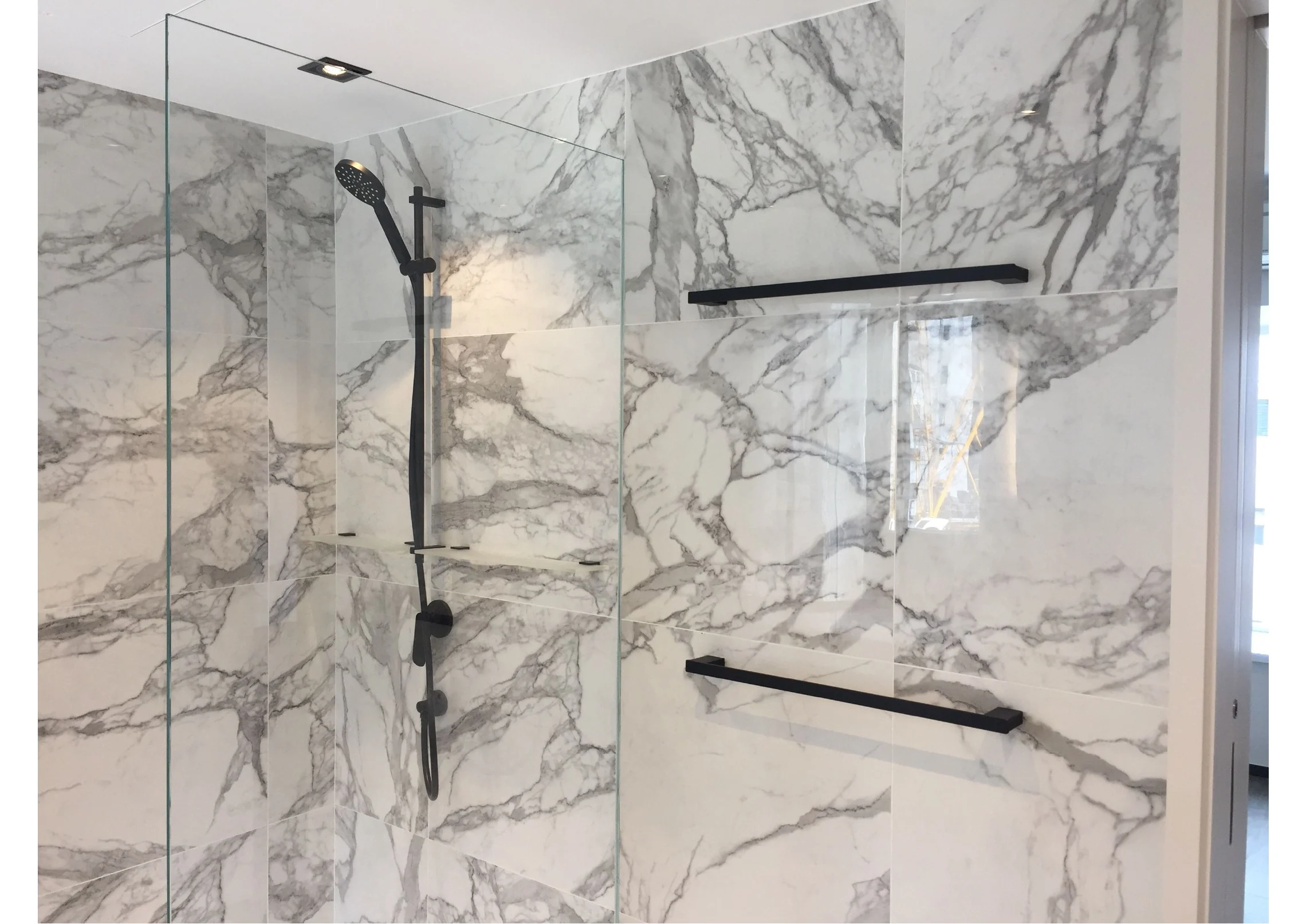Veined stone shower wall and glass screen in the Central bathroom