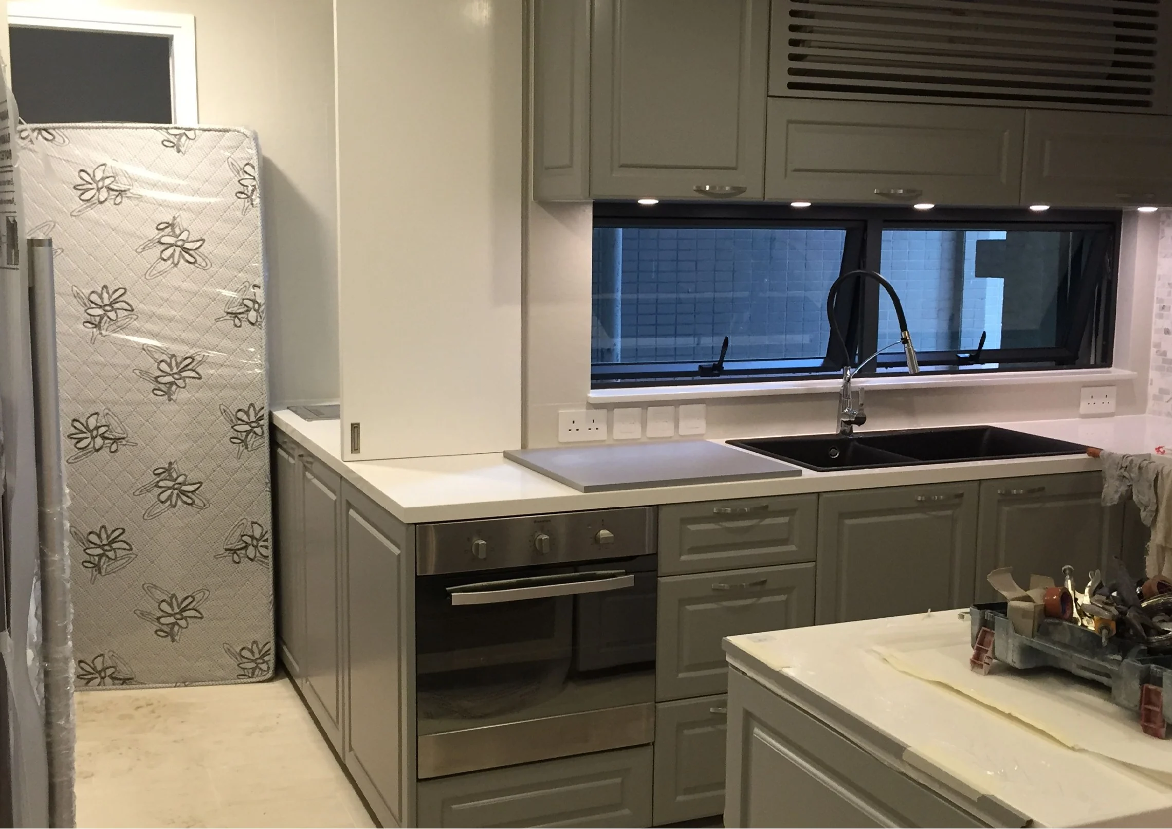 Kitchen cabinetry and pale worktops viewed from the sink side