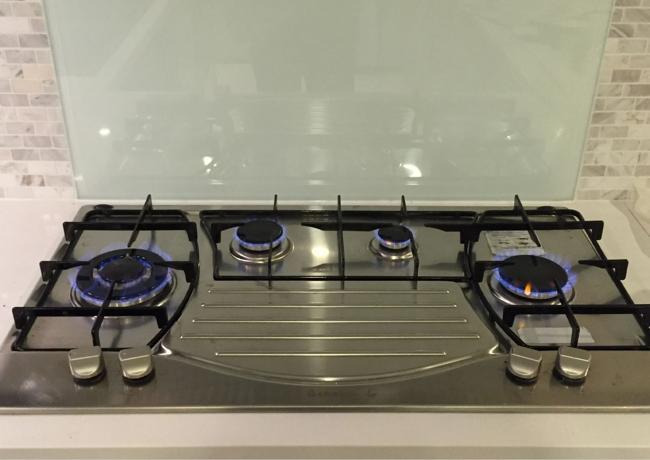 Gas hob and tiled backsplash in the Mid-Levels kitchen