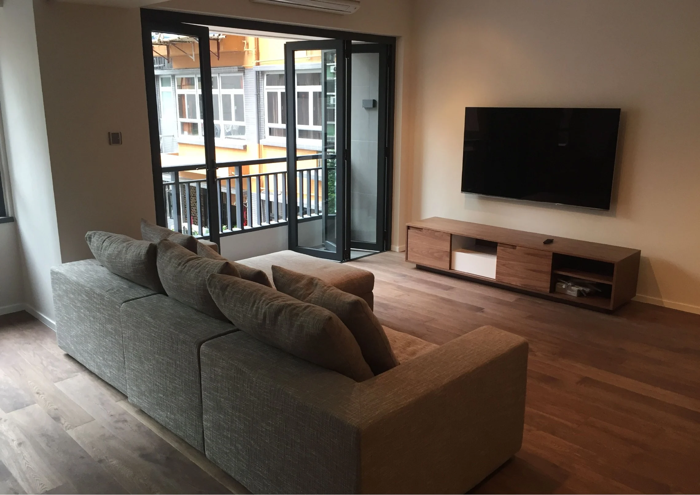 Living room with timber flooring and media cabinetry in the Mid-Levels home